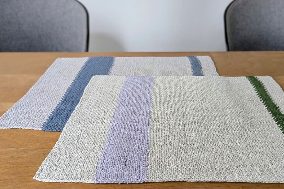 Beitragsbild zu handgestrickten Tischsets ready - zwei Varianten auf einem Esstisch mit Holzplatte